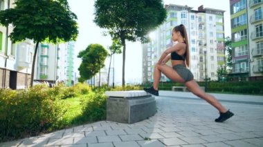 Spor salonundaki kadın dışarıda bacağını esnetiyor..