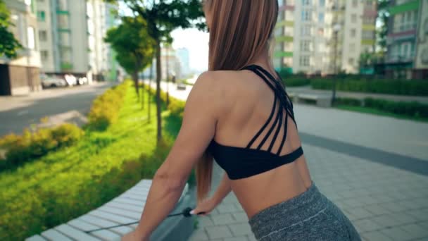 Kadın vücudunun üst kısmını dışarıda direnç bandı kullanarak eğitiyor.. — Stok video
