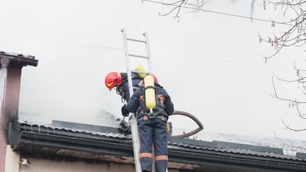 Δύο πυροσβέστες σβήνουν φωτιά με μάνικα στην οροφή.. — Αρχείο Βίντεο