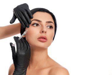 Güzellik uzmanının güzellik iğnesi yaptırdığı çarpıcı esmer.