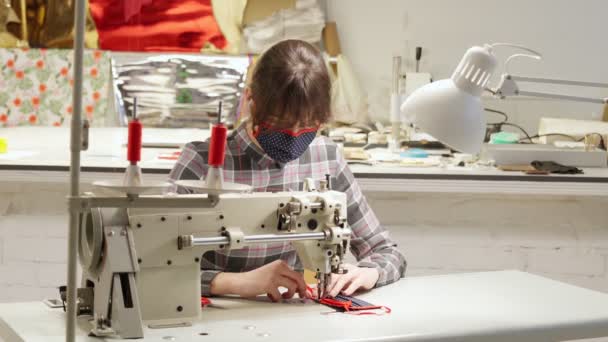 Компетентная швея с помощью швейной машинки для создания маски — стоковое видео