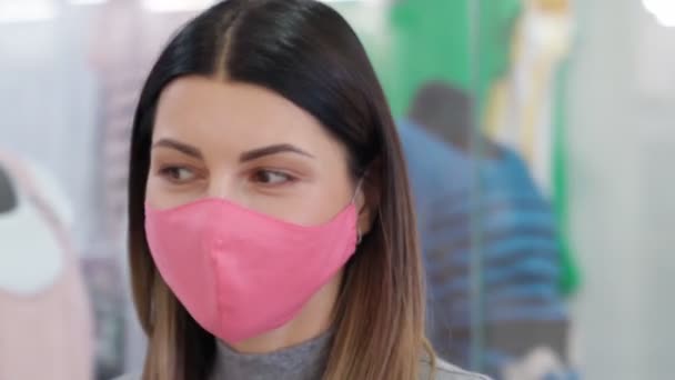 Вагітна жінка в захисній масці ходить в торговому центрі — стокове відео