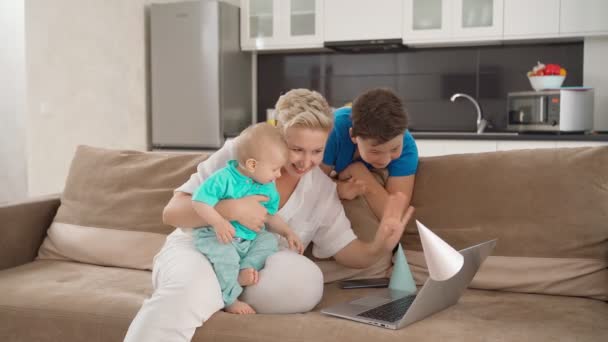 Anne ve iki oğlu laptopta görüntülü arama yapıyorlar. — Stok video