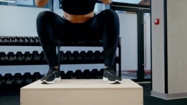 Spor salonunda egzersiz yapan genç bir kadın..