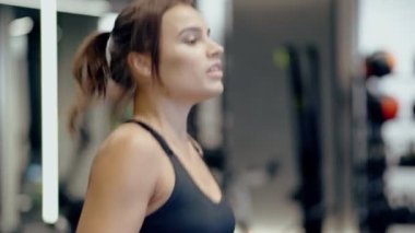 Gülümseyen kadın koşu bandında egzersiz yapıyor..