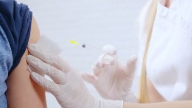 Üniformalı hemşire ve lastik eldivenli çocuk için iğne yapıyor..