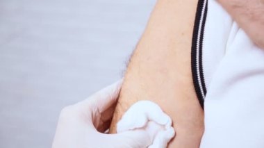 Hemşire klinikteki yaşlı adama iğne yapıyor..