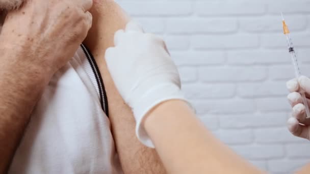 Enfermera con guantes blancos inyectable para hombre mayor. — Vídeo de stock