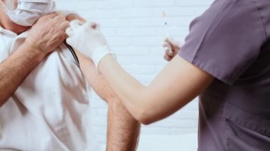 Hemşire kıdemli hastaya iğne yapıyor..