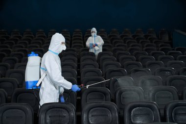 İşçiler sinema salonunu özel dezenfektanlarla temizliyor..