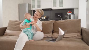 Kanepede oğullarıyla oturan bir kadın.