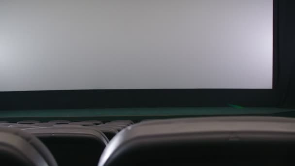 흰색 화면 과검은 의자가 있는 실내 극장. — 비디오