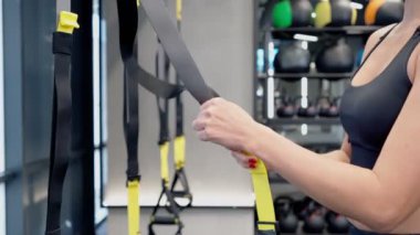 Antrenör TRX sistemini alıştırma için hazırlıyor.