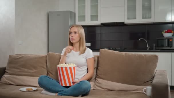 Wanita bahagia menonton film dan makan popcorn di rumah — Stok Video