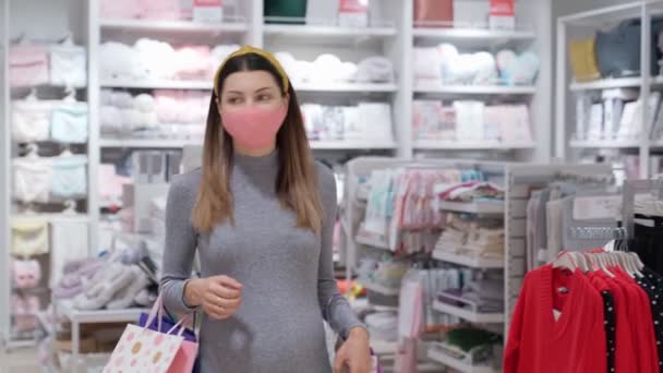 Junge schwangere Frau mit Maske beim Einkaufen im Geschäft — Stockvideo