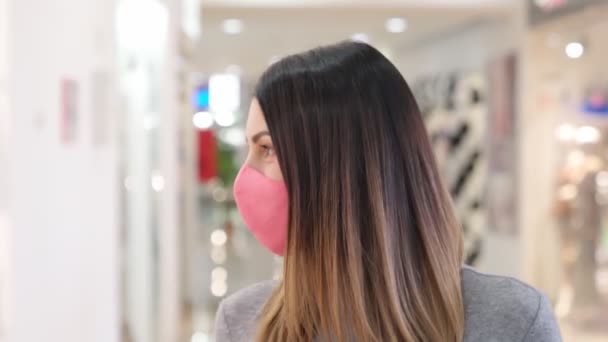 Mulher grávida em máscara andando com sacos no shopping — Vídeo de Stock