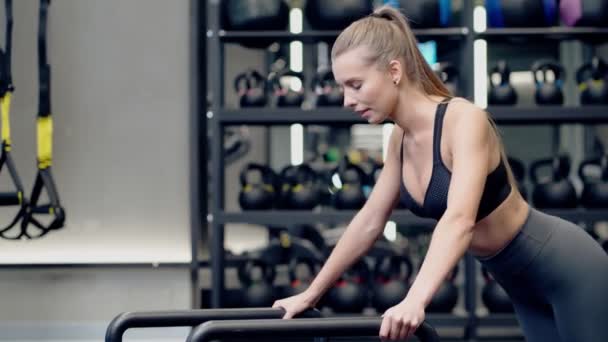 Sportowa kobieta robi ćwiczenia w nowoczesnej siłowni. — Wideo stockowe