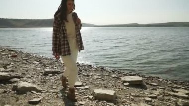 Sırt çantalı bir kadın Bakota körfezinde yürüyor.