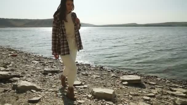 バコタ湾の河川敷をバックパック歩く女性 — ストック動画