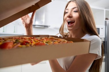 Mutlu kadın evde pizzayla kutuyu açıyor..