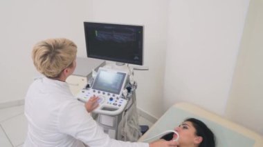 Doktor göğsünü incelemek için ultrason cihazı kullanıyor..