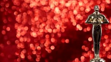 Kırmızı arka planda gümüş ödül kupası.