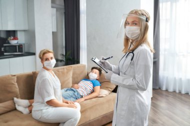 Pediyatrist hasta çocuğu evinde ziyaret ediyor.