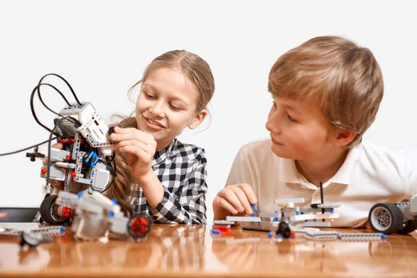 Молодые друзья создают робота с помощью строительного комплекта. — стоковое фото