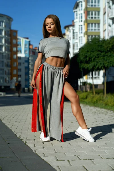 Fashionabla sportig kvinna poserar nära flervåningshus. — Stockfoto