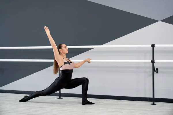 Adult woman stretching in ballet studio.