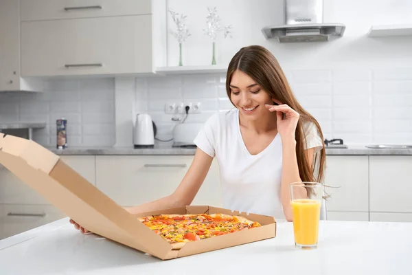 Uśmiechnięta kobieta trzyma dużą smaczną pizzę. — Zdjęcie stockowe