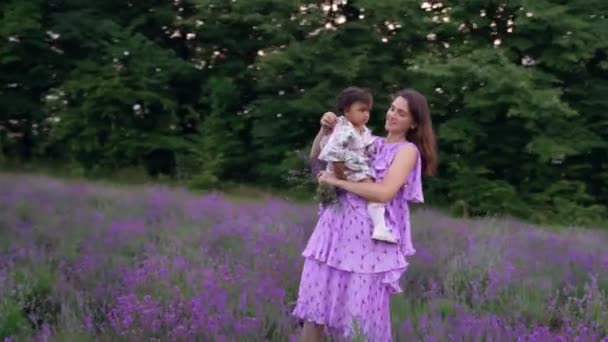 Мать танцует с ребенком на руках в лавандовом поле. — стоковое видео