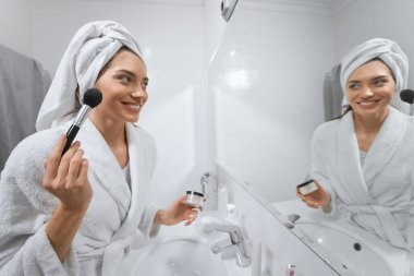 Güzel kadın banyo yaptıktan sonra makyaj yapıyor.. 