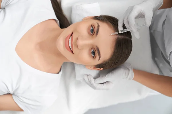 Mulher fazendo procedimento para melhorias na testa da pele. — Fotografia de Stock