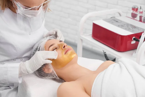 Vrouw liggend in schoonheidsspecialiste en doen procedure voor gezicht. — Stockfoto