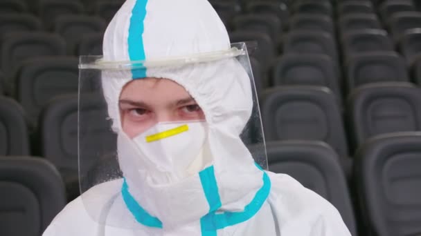 Worker in protective suit holding dispenser. — Stock Video