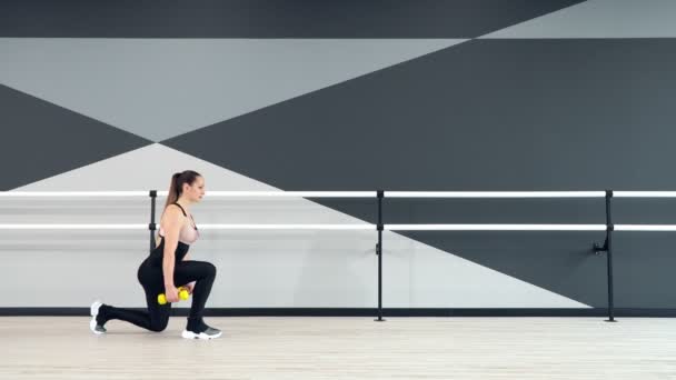 Fitnesswoman praticando lunges usando halteres. — Vídeo de Stock
