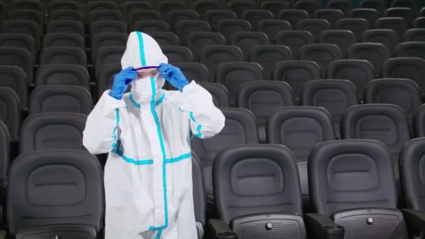 Desinfectante en traje protector limpieza sala de cine — Vídeos de Stock