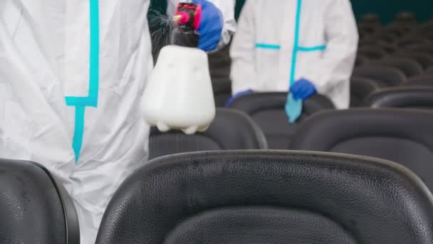 Trabajadores limpiando sillas con desinfectantes en el cine. — Vídeos de Stock