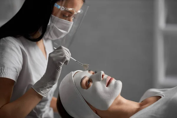 Mujer acostada en el procedimiento para limpiar la cara en esteticista. — Foto de Stock