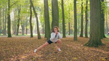 Şehir parkında bacaklarını açan hoş bir kadın.