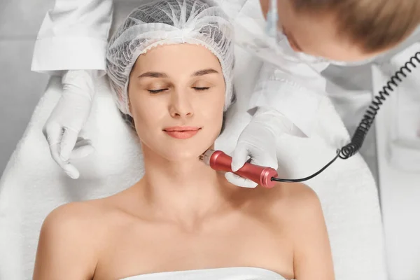 Mujer disfrutando de procedimiento de limpieza o masaje para la cara. — Foto de Stock