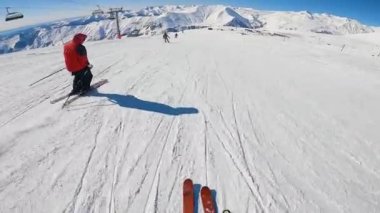 Kayakçı elinde kamerayla yamaçta geziyor..