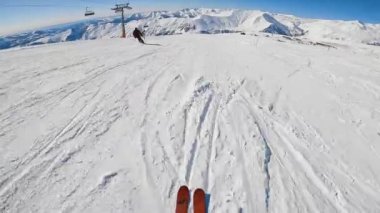 Kayakçı elinde kamerayla yamaçta geziyor..