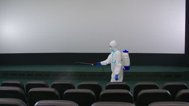 Pracovník čištění kinosál s proti koronaviru. — Stock video