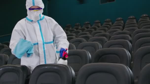 Mannelijke reiniger maakt desinfectie van stoelen in de bioscoop — Stockvideo