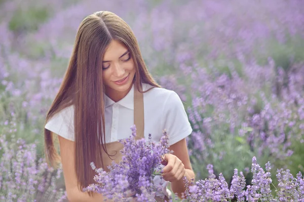 Happy girl mengoleksi bunga lavender di lapangan. — Stok Foto