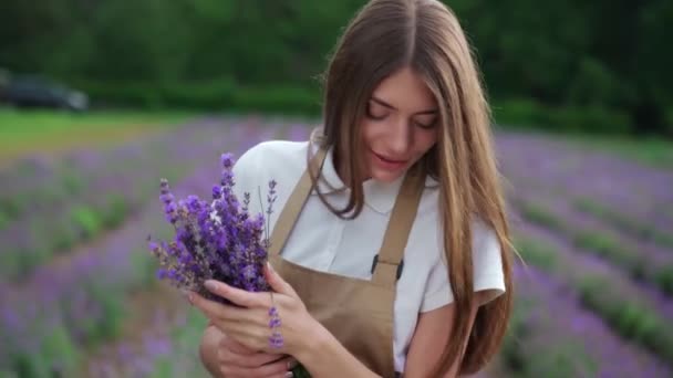 Šťastná dívka pózuje s levandulovou kyticí v poli. — Stock video