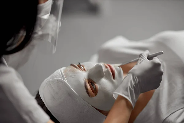 Kosmetička dělá speciální kosmetický zákrok pro pacienta. — Stock fotografie