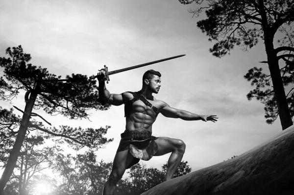 Jeune guerrier musclé avec une épée à la montagne — Photo